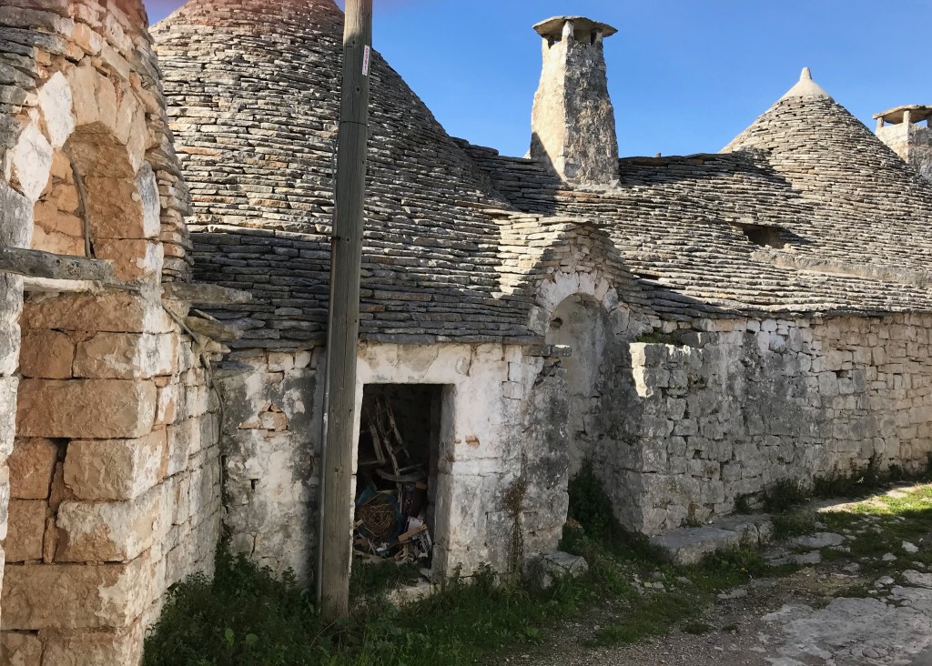 Worn trulli with conical roofs