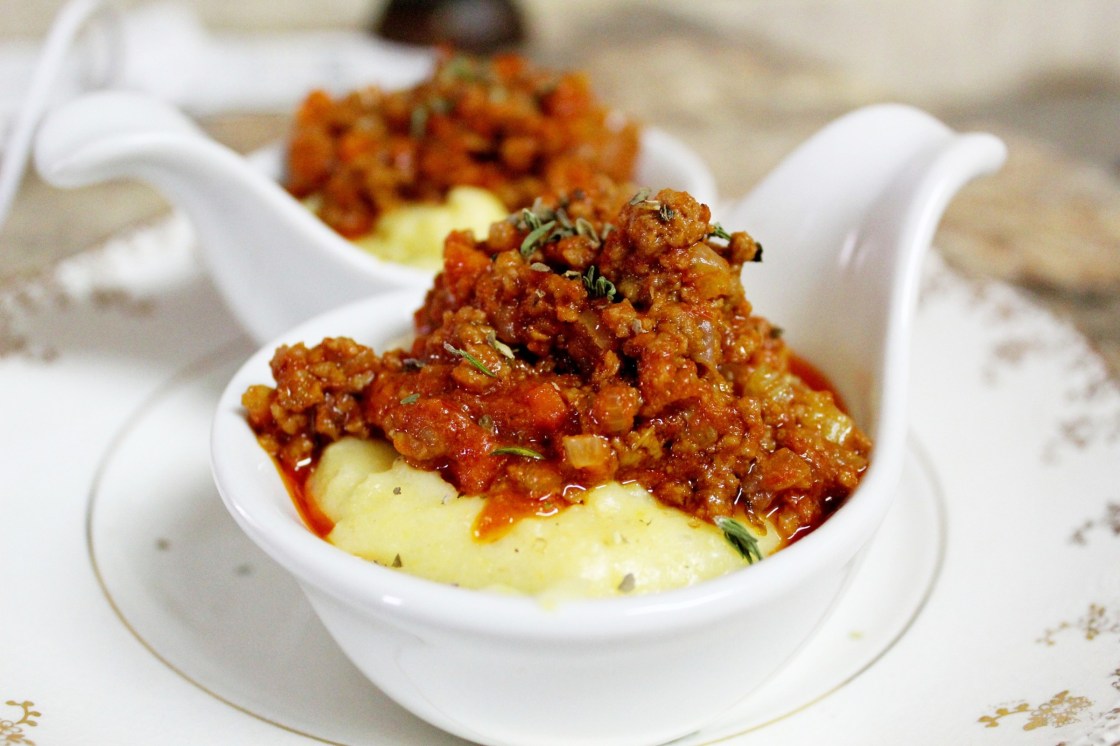 small bowls of creamy polenta covered with meat sauce