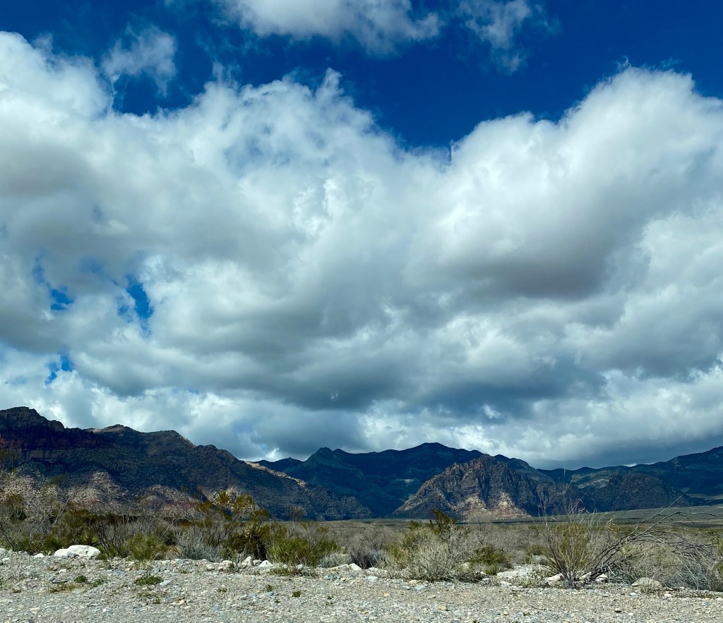 Dark blue sky over calico mountains, desert in front